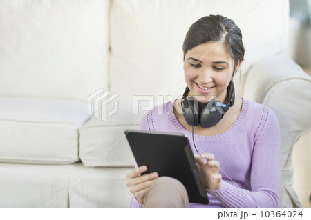 Portrait of teenage girl (16-17) with digital tablet and headphones Portrait of teenage girl (16-17) with digital tablet and headphones 10364024