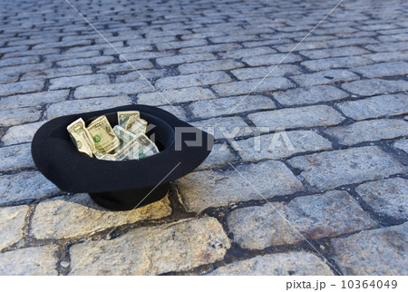 Money in hat on cobblestone street 10364049