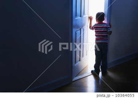 Boy (4-5) peeking through doorway 10364055