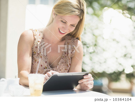 Woman using tablet pc at outdoor cafe table 10364104