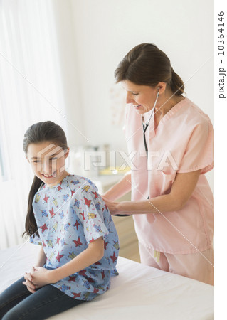 Doctor examining girl (8-9) 10364146