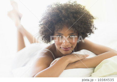 Portrait of woman lying on bed 10364535