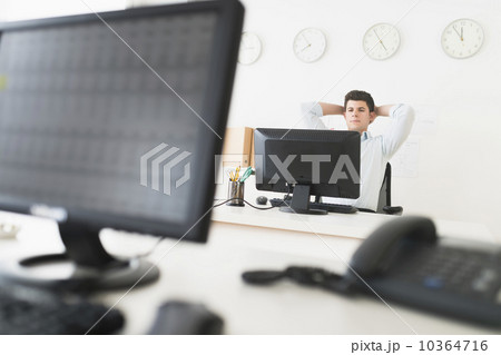Young man sitting in front of desk and working 10364716