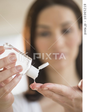 Woman using hand sanitizer 10365219