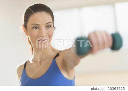 Portrait of woman lifting weights 10365625