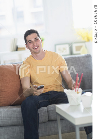 Man eating take out meal and watching television 10365678