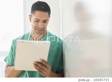 Male surgeon reading medical chart in hospital 10365735
