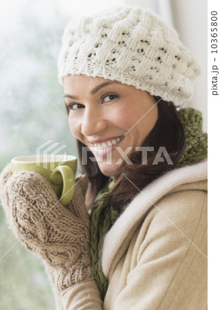 Portrait of woman in warm clothes holding mug 10365800