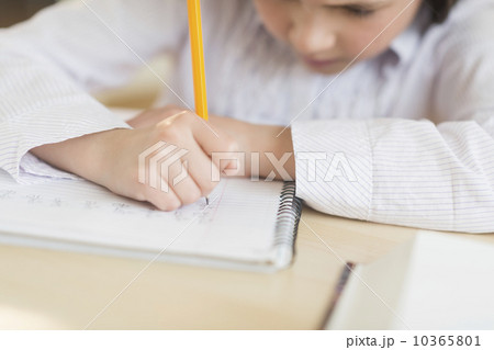 Girl (8-9) doing homework 10365801