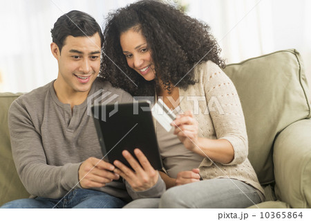 Couple using digital tablet on sofa 10365864
