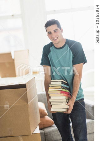Man packing books into cardboard box at home Man packing books into cardboard box at home 10365934