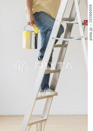 Man holding paint can and climbing ladder Man holding paint can and climbing ladder 10366009
