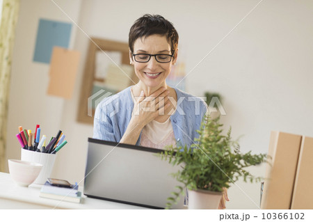 Woman using laptop in home office 10366102