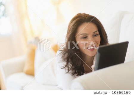 Woman on sofa using tablet pc Woman on sofa using tablet pc 10366160