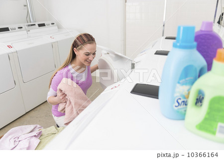 Woman loading laundry into washing machine 10366164