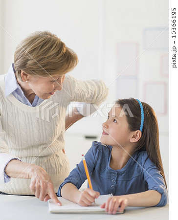 Teacher helping schoolgirl (8-9) at school 10366195