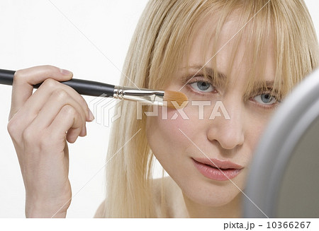 Woman with cosmetic brush and mirror Woman with cosmetic brush and mirror 10366267