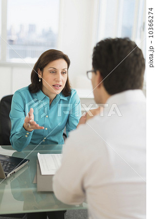 Businessman and businesswoman discussing in office 10366274