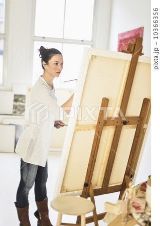 Woman painting at easel 10366356