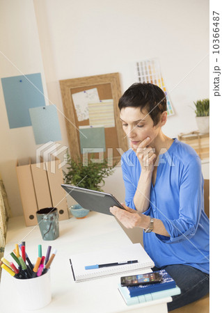 Woman using digital tablet in home office 10366487