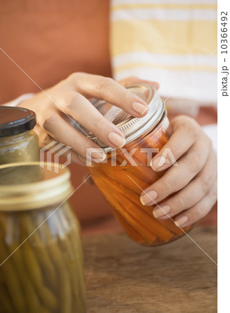 Woman closing jar with pickled vegetables 10366492