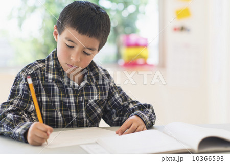 Boy (6-7) writing at school 10366593