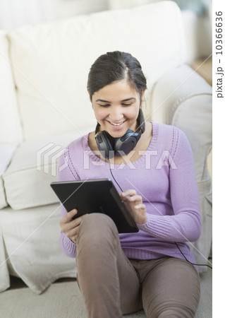 Portrait of teenage girl (16-17) with digital tablet and headphones Portrait of teenage girl (16-17) with digital tablet and headphones 10366636
