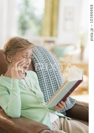 Senior woman reading book at home 10366668