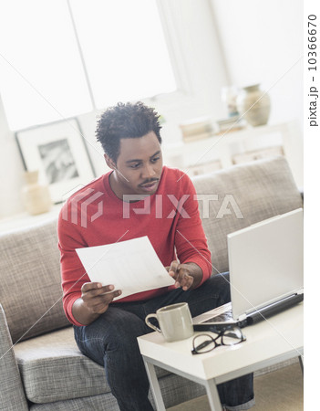 Man sitting on sofa and using laptop 10366670
