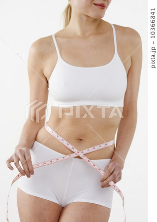 Woman's torso encircled by tape measure 10366841