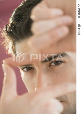 Portrait of man making finger frame 10366872