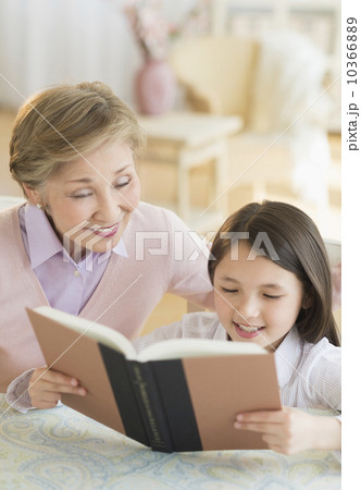 Granddaughter (8-9) and grandmother reading book Granddaughter (8-9) and grandmother reading book 10366889