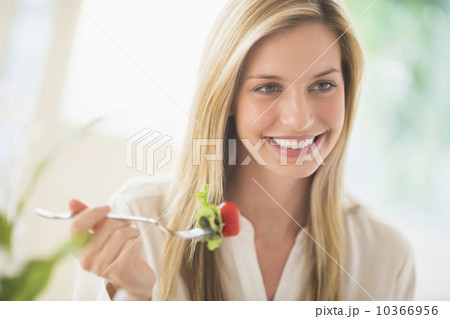 Woman eating and smiling 10366956