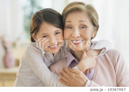 Granddaughter (8-9) embracing grandmother 10367067