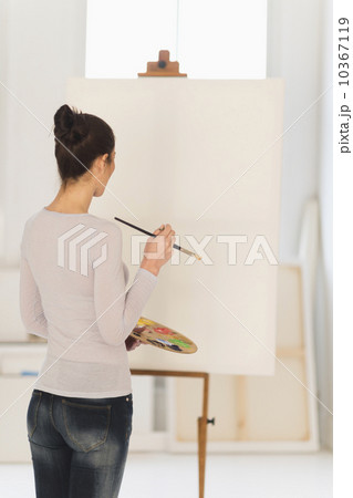 Woman painting at easel 10367119