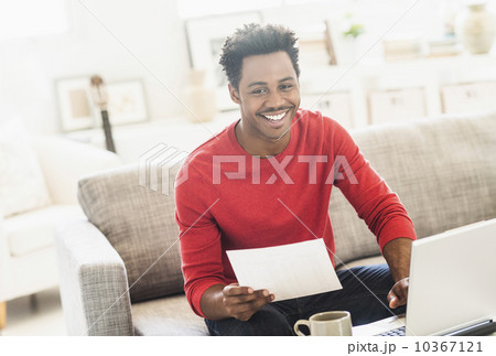 Man sitting on sofa and using laptop 10367121