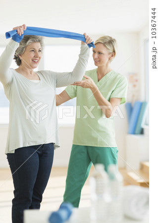 Mature woman exercising with personal trainer 10367444