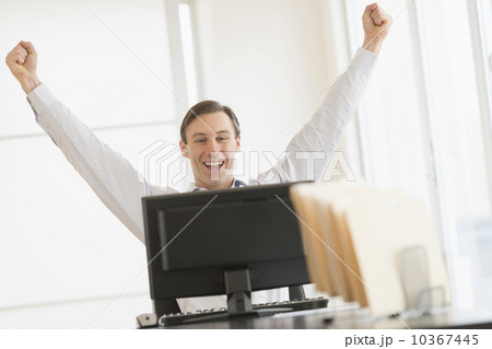 Office worker cheering in front of computer 10367445