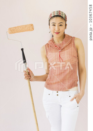 Woman holding paint roller Woman holding paint roller 10367458