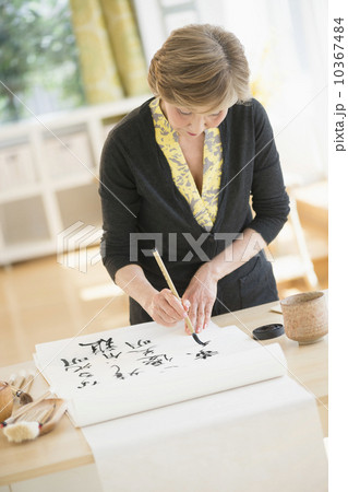 Senior woman painting japanese symbols 10367484