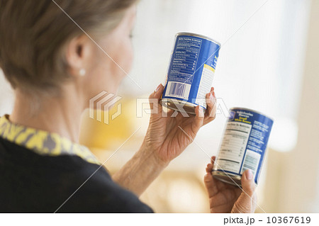 Senior woman reading labels on canned food 10367619