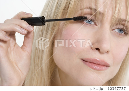 Woman looking sideways applying mascara 10367727