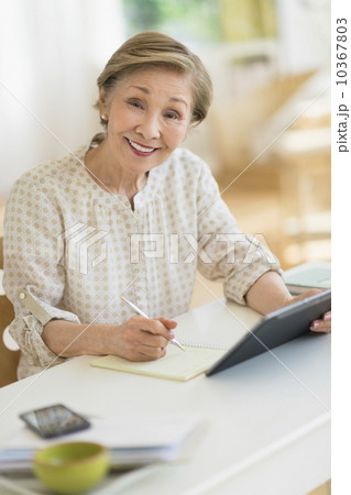 Senior woman using tablet pc at home 10367803