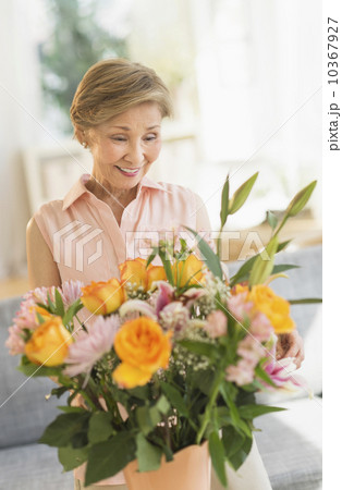 Senior woman arranging flowers at home Senior woman arranging flowers at home 10367927
