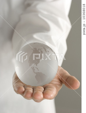Glass globe held in outstretched hand 10368018