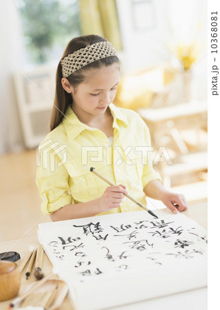 Girl (8-9) painting japanese symbols 10368081