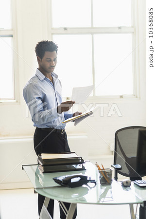 Businessman reading documents in office 10368085