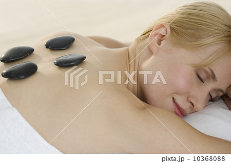 Prone woman with stones on back Prone woman with stones on back 10368088