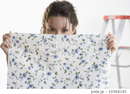 Woman hiding behind piece of wallpaper 10368185