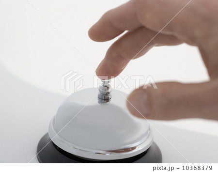 Closeup of hand ringing desk bell 10368379